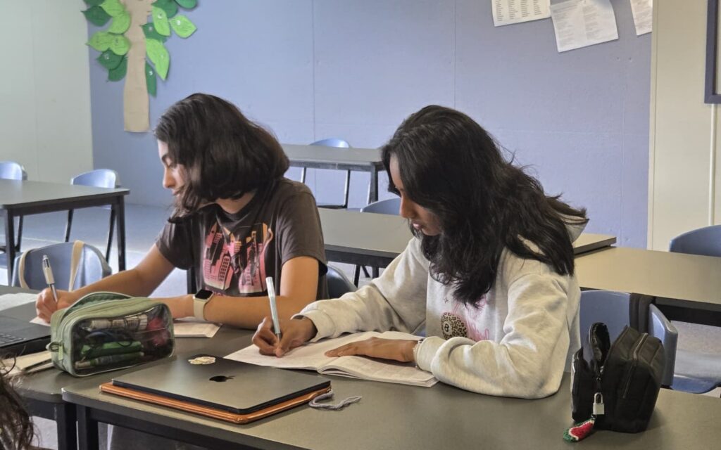 Two NRICH Learning students focused on their written practice work