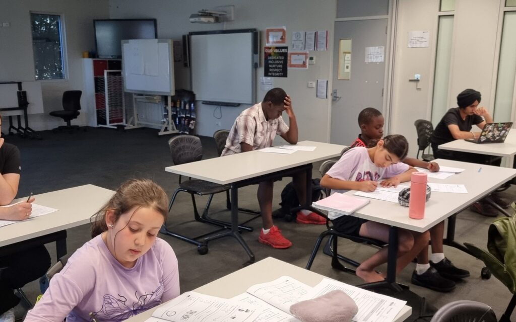 NRICH Learning students completing practice test papers in a small-group classroom